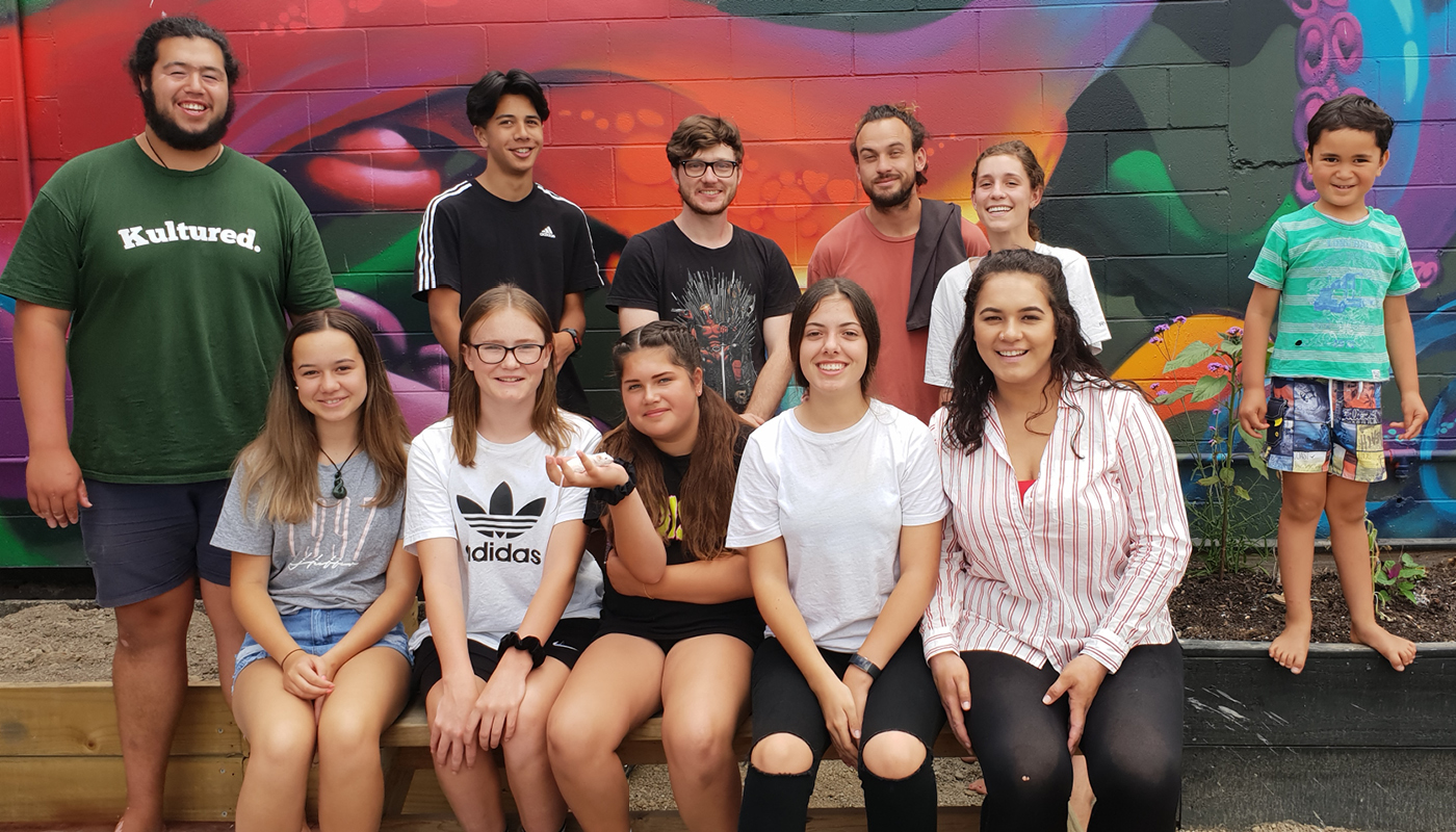 Bub cast and crew - a group of people stand in front of a mural