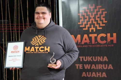 Māori boy experiences VR for the first time wearing a VR headset. He reaches out to touch something in the experience. 